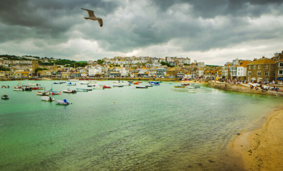 Dramatic cloudscape and scenic panorama of beach of St Ives coastal town, Cornwall, England