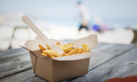 Box of Chips on a beach Bench.