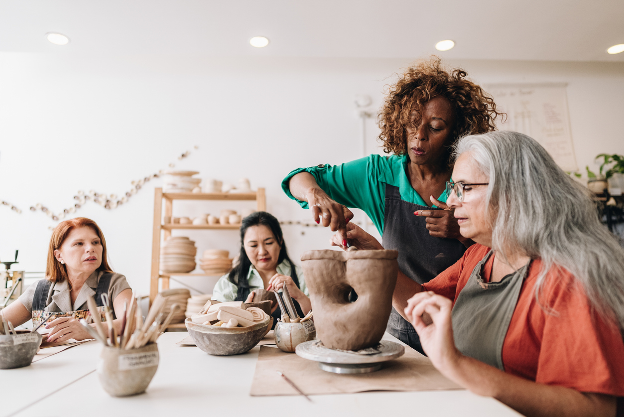Pottery teacher teaching her student at a ceramics workshop