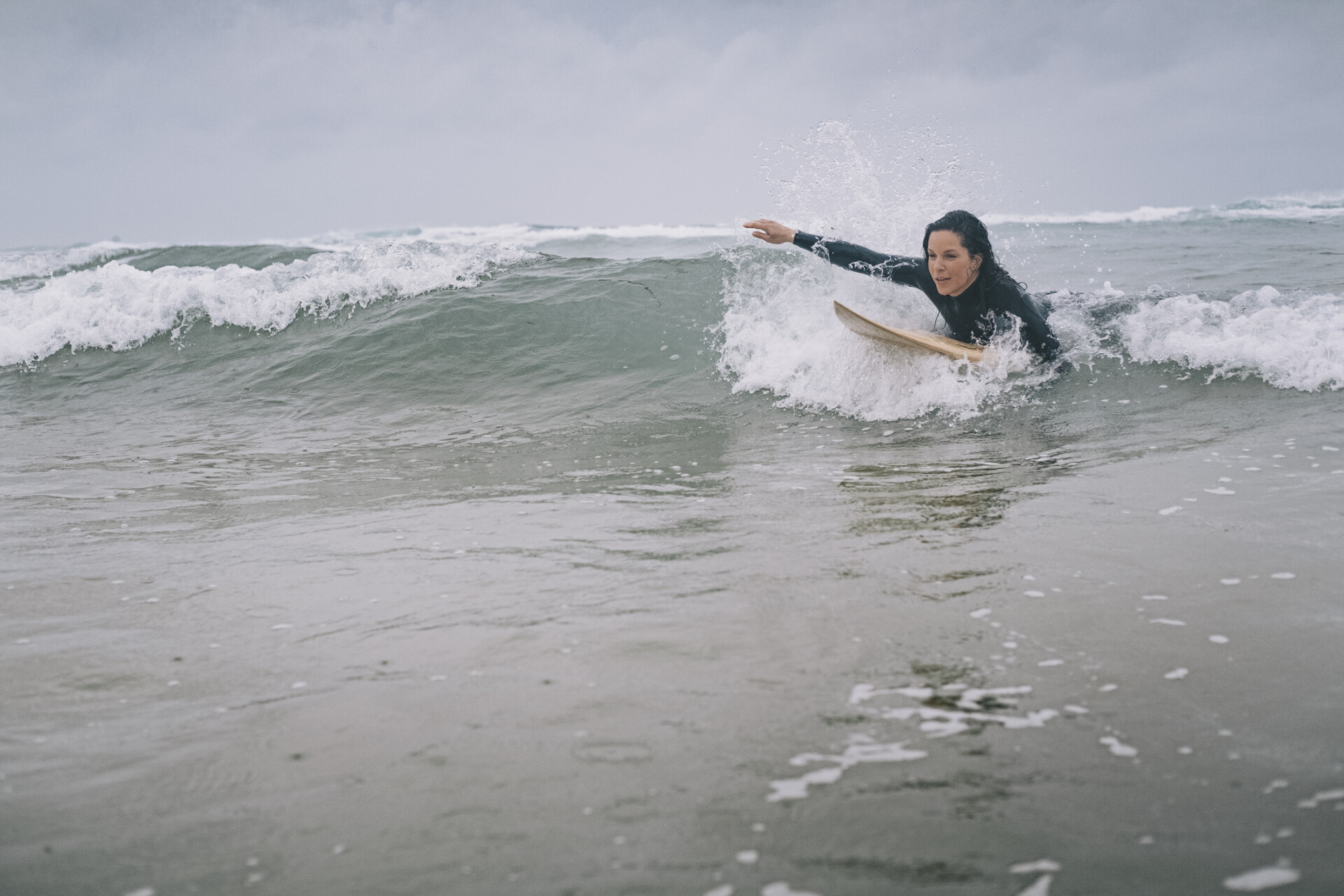 Female Surfer Paddling on surfboard, Perranporth, Cornwall
